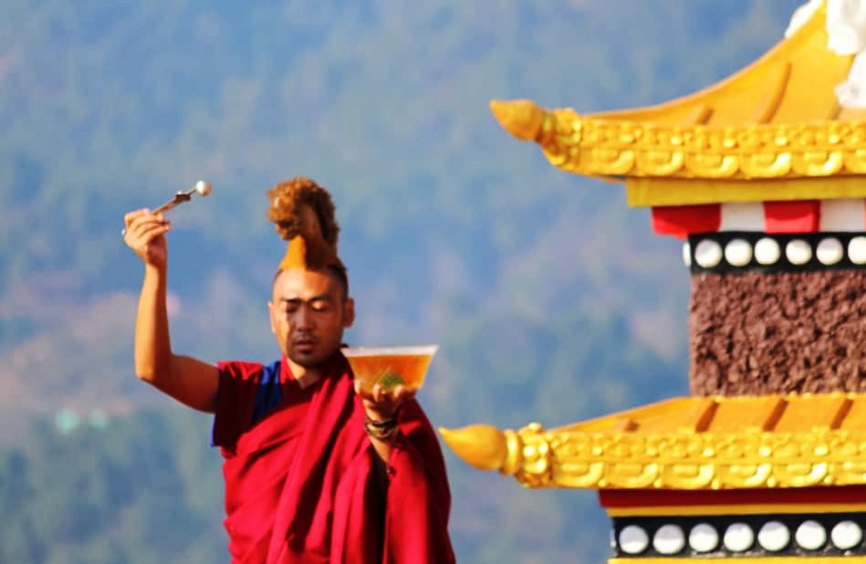 Монах традиции Юнгдруг Бон в монастыре Менри совершает подношение нектара Монах традиции Юнгдруг Бон в монастыре Менри совершает подношение нектара